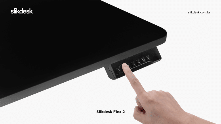 detalhe do quina da mesa flex 2 preta, mostrando a quina arredondada e bordas retas, podemos vê também uma mão de pessoa branca utilizando o dedo indicador para apertar o botão de controle no painel da mesa.